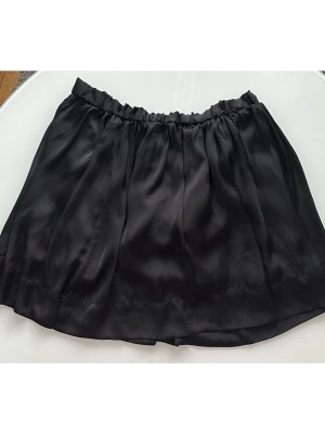 Svart Gina Tricot kjol i satin, storlek 44 - Superfin Gina Tricot kjol i storlek 44. Kort, svart kjol i glansig satin med resår i midjan. Yttertyget är lätt och följsamt, och kjolen har ett innerfoder för ökad komfort och bättre vidd. Lika fin till vardag som till fest! 