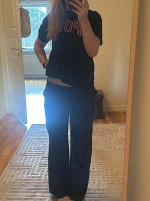 Svarta vida mjukisbyxor - Säljer ett par svarta mjukisbyxor med bred passform och dragsko i midjan. Byxorna har en avslappnad look och är perfekta för chill dagar. Tillverkade i mjukt material som känns skönt mot huden.