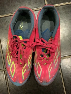 Adidas F50 rosa fotbollsskor - Snygga Adidas F50 fotbollsskor i en skarp rosa färg med gula och vita detaljer. Skorna har snörningoch dobbar för spel på gräs och konstgräs. 6/10 skick 