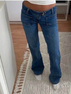 Blå low waist jeans med raka ben💕 - Säljer ett par blå low waist jeans med raka ben och dubbla knappar i midjan. Jeansen har framfickor och en klassisk femficksdesign. Passar dig som älskar ett par low waist jeans! Jeansen är jätte snygga men tyvärr är dem alldeles för långa vid benen. Jag är 162cm. Har använt jeansen 1gång.💕