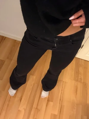 Svarta bootcut jeans från ONLY - Säljer ett par svarta bootcut jeans från Only. Snygg passform som sitter tajt över låren och släpper ut vid benslut. Perfekta till en trendig vardagslook.