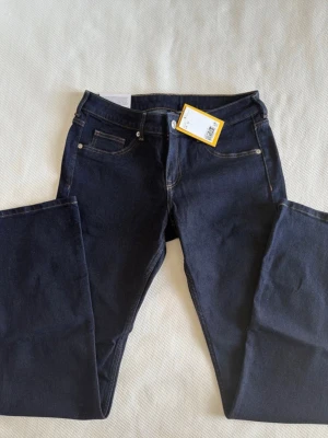 Mörkblå lågmidjade flare jeans - Snygga mörkblå jeans som är flare. Jeansen har kontrastsömmar och metallknapp i midjan. Perfekta för dig som gillar en enkel och stilren look. Byxorna är full length. Innerbensmått 83cm Midjemått tvärs över 38cm Midjehöjd 23cm Benvidd nertill 27cm 💕