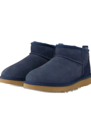 Mörkblå UGG Classic Mini boots - Säljer ett par mörkblå UGG Classic Mini boots i mocka med beige sula. Skorna har en låg ankelhöjd och är fodrade med mjukt fårskinn på insidan. Perfekta för kalla dagar och riktigt sköna att ha på sig. (Priset kan diskuteras då det är lite färgskadade)