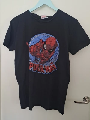 Spiderman t-shirt - Svart t-shirt från Marvel med ett stort Spiderman-tryck i rött och blått på framsidan. Klassisk rund hals och korta ärmar. Hittar inga defekter. 🩷