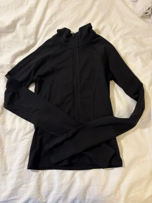 Svart träningströja från Gina Tricot - Svart träningströja från Gina Tricot med hög krage. Tillverkad i stretchigt funktionsmaterial som sitter tajt och är perfekt för träning. Använd max 2 ggr💗