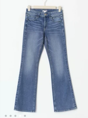 GinaTricot Jeans - Säljer ett par blå bootcut jeans från Gina med klassisk femficksmodell och normalhög midja. Jeansen har en snygg tvättad look och är tillverkade i mjuk denim med lite stretch för extra komfort. Perfekta för en avslappnad och trendig stil.