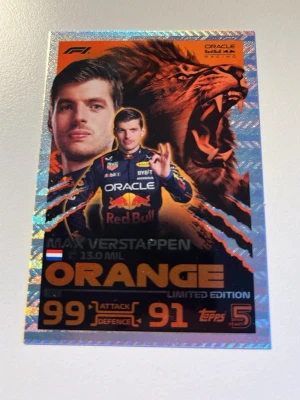 F1 samlarkort Max Verstappen Orange - Samlarkort från Topps med Max Verstappen i Red Bull Racing, Orange Limited Edition. Kortet har holografisk ram, lejonmotiv och detaljer i orange och svart. Attackvärde 99 och försvarsvärde 91. Perfekt för F1-fans och samlare.