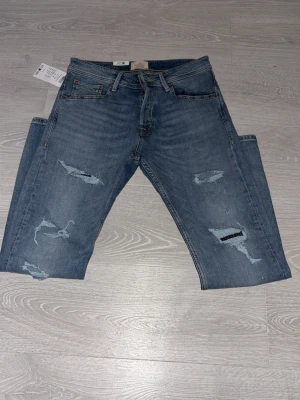 Jack & Jones jeans  - Säljer blå jeans med slitningar från Jack&Jones. Nytt skick med prislapp och oanvända. Säljer då de inte passade mig. Storlek 30/30