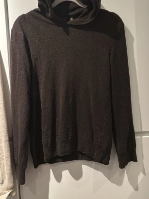 Mörkbrun hoodie från Oscar Jacobson - Snygg mörkbrun hoodie från Oscar Jacobson, tillverkad i Italien. Hoodien har en klassisk huva och är gjord i ett mjukt, tunt material som känns lyxigt. 