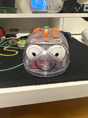 Bee-Bot programmerbar robot - Säljer en Bee-Bot programmerbar robot från TTS. Den är genomskinlig med orange, gröna och blå knappar på ovansidan och har ett gulligt ansikte framtill. Perfekt för att lära sig grunderna i programmering och kodning på ett lekfullt sätt. Säljs också till skolor såklart! 😊