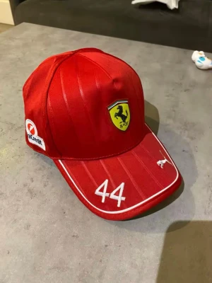 Ferrari keps - Snygg röd keps med Ferrari-logga. Alla loggor är broderade i högsta kvalité. Helt ny och är inte använd. 