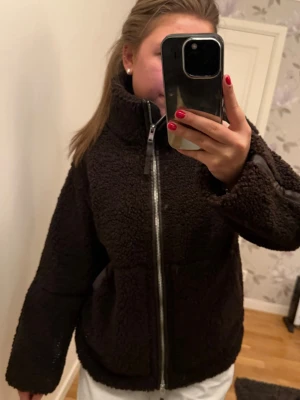 Svart teddyjacka med dragkedja - Mysig mörkbrun teddyjacka med hög krage från Hm i xs. Använd fåtal gånger, säljer pga att jag har massa jackor!☺️☺️