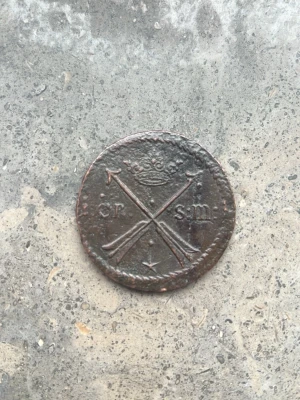 Stor gammal svensk kopparmynt - Unik stor kopparmynt med Dalarna pilar, krona och texten 'ör sm'. Myntet har en mörkbrun patina och är betydligt större än en vanlig enkrona. Perfekt för dig som samlar på äldre svenska mynt eller gillar historiska föremål. Från 1680 år