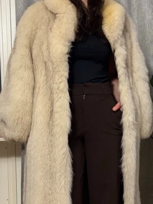 Lång vit silverrävspäls  - Säljer en supermjuk och fluffig lång silverrävs pälsjacka. Jackan har en oversized passform med breda ärmar och stora fickor på sidorna. Perfekt för dig som vill ha en statement piece till vintern. Ingen synlig logga eller märke. Tillverkad i Sverige