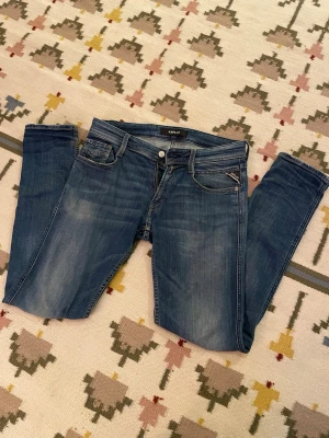 Replay Anbass - Säljer ett par blå Replay anbass slim fit med snygga slitningar. Jag har ägt dem i ett par år nu och dragkedjan är bytt vid ett tillfälle. I övrigt är de i bra skick bortsett från ett ställe där en sömm har släppt. Detta varken märks eller skadar då det är dubbelsöm vid skadan (se bild). Storlek W29 L32 