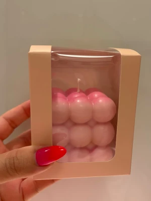 Rosa bubbel-ljus i presentförpackning - Unik rosa bubbel-ljus i kubform, levereras i en ljusrosa presentförpackning med genomskinligt fönster. Ljuset har en cool design med bubblor och är perfekt som dekoration eller present.