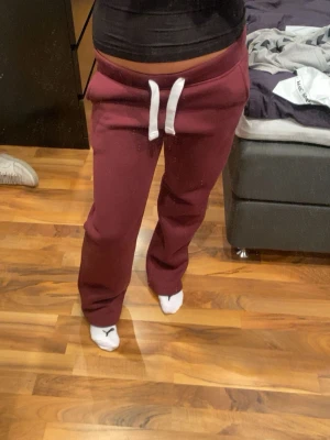 Vinröda Russemerch - Säljer ett par vinröda Russemerch mjukisbyxor i storlek S. Jag klippte bort lappen så jag tyckte att den kliades. Jag är 166 och dom sitter perfekt på mig och är knappt använda!💞