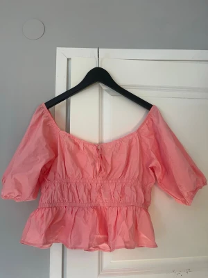 Rosa offshoulder topp från H&M - Rosa sommartopp från HM i storlek L men är lite liten i storlek enligt mig. Använd 1 gång 
