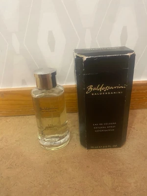 Baldessarini Eau de Cologne 75 ml - Baldessarini Eau de Cologne i en elegant glasflaska med silverfärgat lock. Doften kommer i originalförpackning, en svart kartong med guldtext. Flaskan rymmer 75 ml och har en klassisk, stilren design som passar perfekt för dig som gillar exklusiva parfymer.