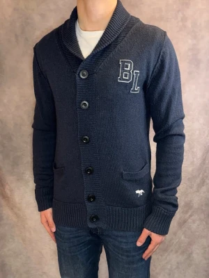 Marinblå Bondelid Cardigan - Stl M - Riktigt snygg Cardigan från Bondelid i färgen marinblå | Mycket bra skick: 9/10, inga defekter | Stl: M, modellen är 177cm och väger 75kg, passar bra men också längre 🙌  | Hör av dig vid frågor // Galgen 🫡