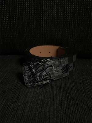 L--v bälte - Svart rutigt bälte. Silver logga. Snyggt.