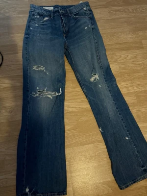 Blå jeans - Säljer dessa snygga jeans ifrån Zara, perfekta hål! Storlek 38 och går ända ner till fötterna på mig som är 173cm.