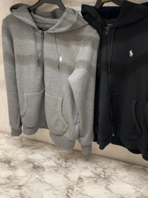 Grå och svart hoodie från Polo Ralph Lauren - Säljer båda för 1350. Båda är xs. Skriv för fler bilder.hör av er vid fler bilder eller bara allmänt fler funderingar.😁