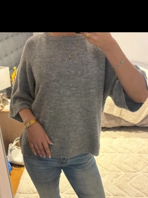 Grå oversized stickad tröja - Mysig grå stickad tröja med oversized passform och trekvartsärmar. 