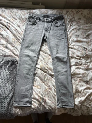 Ljusgrå slim fit jeans Garcia - Säljer ett par ljusgrå slim fit jeans från Garcia Jeans. Jeansen har klassisk femficksmodell, normal midja och raka ben. Materialet är mjukt denim med lite stretch för extra komfort. Perfekta till en avslappnad och trendig look.