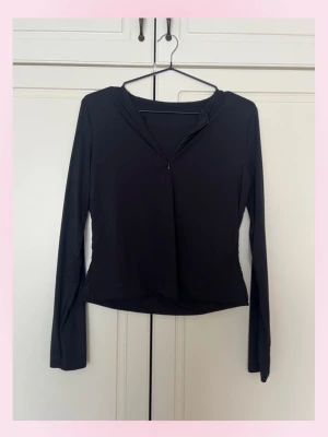 Svart långärmad topp med dragkedja - 💞Stilren svart långärmad topp med liten dragkedja framtill vid halsen. Toppen har en smickrande passform och är tillverkad i ett mjukt, stretchigt syntetmaterial. Perfekt att matcha med jeans eller kjol för en clean look eller sportig 💕