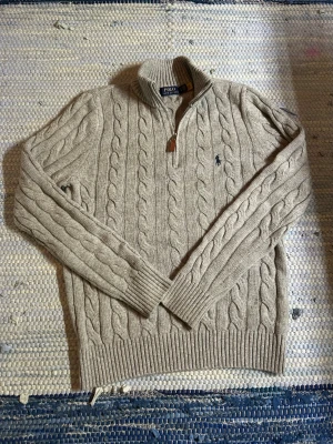 Grå Ralph Lauren Quarterzip - Snygg grå Ralph Lauren Quarterzip, tröjan är i storlek M men skulle passa L också, tröjan är i väldigt fint skick utan några defekter alls. Längd=67cm Bröstvidd=47cm. Pris inte hugget i sten, hör av dig vid minsta fundering!