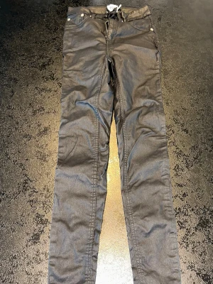 157 coated svarta jeans XS  - Svarta coated jeans från 157 i tight skinny modell. Stretchigt material som sitter snyggt på kroppen. Lite glansig “läderlook”.  Storlek: XS Färg: svart coated Passform: skinny  Skick: bra skick  Perfekta till fest eller vardag 🖤
