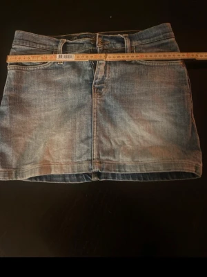 Blå jeanskjol med klassisk look - Jätte fin lågmidjad jeanskjol i storlek XS❣️har en fläck där bak som förmodligen går bort i tvätten men den syns knappt❣️ kom privat för bättre bilder 