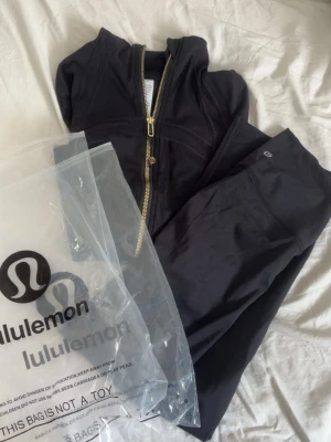 Lululemon set - Snygga svarta leggings från Lululemon i stretchigt och mjukt material. Perfekta för träning eller chill, med diskret logga på benet och hög midja för skön passform. Materialet känns lyxigt och följsamt.
