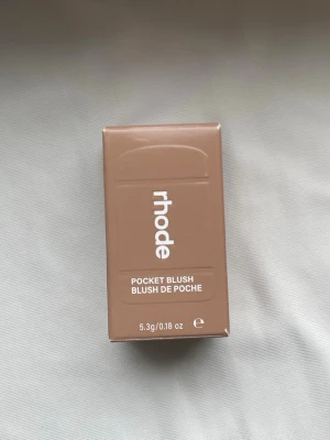 Rhode Pocket Blush Piggy - Rhode Pocket Blush i nyansen Piggy är ett krämrouge i en söt, kompakt förpackning. Färgen är en livlig rosa som ger kinderna en fräsch och ungdomlig look. Perfekt att ha med i väskan för touch-ups. Helt ny och oanvänd ✨
