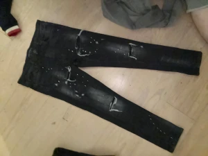 Svarta skinny jeans Supply & Demand  - Svarta jeans från Supply & Demand med skinny passform köpt för 750. De har slitna detaljer och vita färgstänk på benen för en edgy look. Klassisk femficksmodell med knapp och dragkedja. Perfekta för dig som gillar streetstyle.