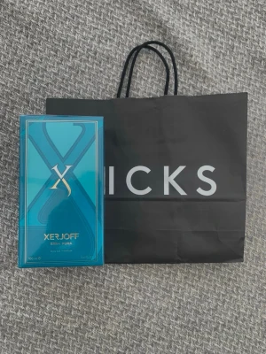 Xerjoff Erba Pura Eau de Parfum - Xerjoff Erba Pura Eau de Parfum i en snygg turkosblå förpackning med gulddetaljer. Lådan har en modern design med ett stort X och exklusiv känsla. Innehåller 100 ml parfym som passar dig som gillar lyxiga dofter.