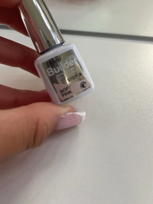 Builder Gel Soft Pink nagellack - Builder Gel Soft Pink, ljusrosa nyans. Perfekt för att bygga och förstärka naglar med en naturlig och fräsch look. Kommer i en liten vit flaska med silverlock och är enkel att applicera.