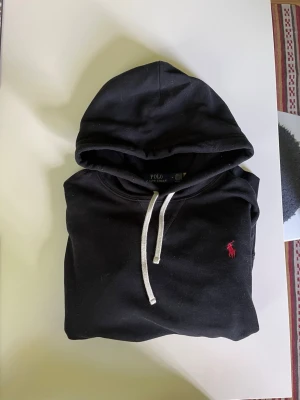 Svart hoodie från Polo Ralph Lauren - Hoodie från Polo Ralph Lauren, Skick 8,9/10🙌   Nypris: 2399kr. Mitt pris: 659kr🤝                                Levererar snabbt och är aktiv för frågor och annat tveka inte att fråga eller något. Storlek M.