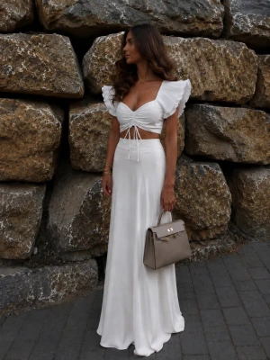 Vit crop top med volangärmar - Trendig vit crop top med djup v-ringning, volangärmar och rynkade detaljer framtill. Toppen har knytband i midjan och är tillverkad i ett lätt, luftigt material som passar perfekt till sommarens outfits. Har en liten fläck framtill men som säkert kan gå att få bort med fläckborttagning i tvätten💕