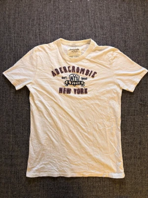 Vit t-shirt från Abercrombie & Fitch - Sjukt eftertraktad Abercrombie & fitch T-shirt  – 2000’s modell och sjukt sällsynt, stl xxl men sitter som L. Fint skick och sitter riktigt bra, perfekt till vardag 🌿  Kan även gå ner lite i pris vid snabb affär ✌️ Skickas inom 24h 📦