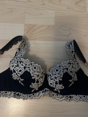 Intimissmi bh  - Elegant svart bh med vacker vit blommig spetsbrodyr över kuporna och längs kanterna. Bh:n har bygel och breda axelband med spetsdetaljer för extra stöd och en lyxig känsla. Perfekt för dig som gillar romantiska detaljer och snygg design. Skriv för fler bilder, pris kan diskuteras💕💕