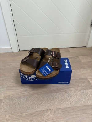 Bruna Birkenstock  - Bruna brikenstock storlek 45. Aldrig använda. Prislapp sitter kvar. Boxen följer med!
