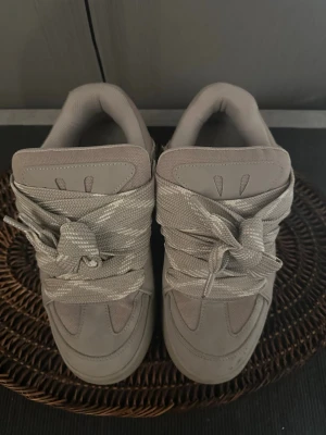 Beige chunky sneakers med bred sula - Snygga chunky sneakers i beige med breda matchande skosnören och tjock sula. Ovandelen är i en mix av mocka och mesh för både stil och komfort. Perfekta för dig som gillar en clean och modern look.