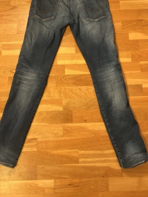 Replay Anbass - Snygga blå slim fit jeans med lätt slitna detaljer och klassisk femficksmodell. Jeansen har en tvättad look. Tillverkade i denim med en smal passform som sitter fint längs benen.