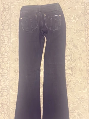  G rise jeans Svarta bootcut jeans - Snygga svarta bootcut jeans med klassiska bakfickor och femficksmodell. Jeansen har en lätt utsvängd passform nedtill och är tillverkade i ett stretchigt denimtyg för extra komfort. Perfekta för dig som gillar en retroinspirerad look.