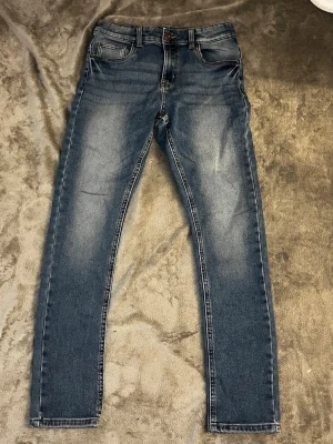 Blå slim fit jeans  - Snygga blå slim fit jeans med klassisk femficksdesign. Jeansen har normalhög midja och raka ben. Perfekta för en avslappnad och trendig look. Materialet är troligtvis bomull med stretch för extra komfort. Vid frågor hör av dig och priset kan alltid diskuteras 