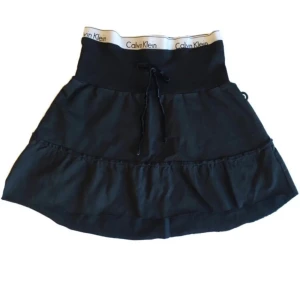 Calvin Klein minikjol/ miniskirt/ tygkjol/ volangkjol, y2k/ cyber/ alt/ 2000s/ 2000tal/ 00s/ 00tal/ sommarkläder  - Unik mini-tygkjol med påsydd Calvin Klein resår & med velourband! (Obs! Man får sätta på sig den försiktigt då sömmen kan gå upp om det stretchas ut för mycket) kjolen är avklippt längst ner, går att klippa kortare om man vill ha den ännu mer ”mini”