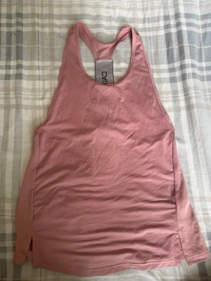 Rosa träningstopp från Calvin Klein - ⚠️Säljer en likadan i L kika in så du kan matcha med någon⚠️ Säljer ett rosa linne från Calvin Klein, perfekt för gymmet eller löpning. Linnet har brottarrygg och är gjort i ett mjukt, stretchigt material som andas. Snygg passform som ger bra rörelsefrihet.