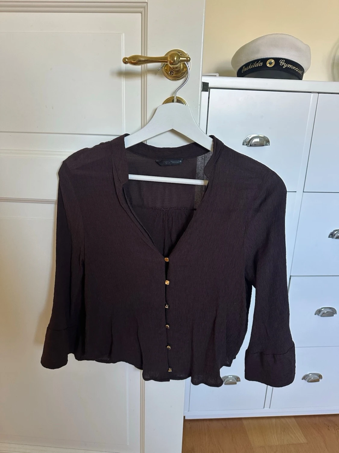 Brun blus med knappar framtill